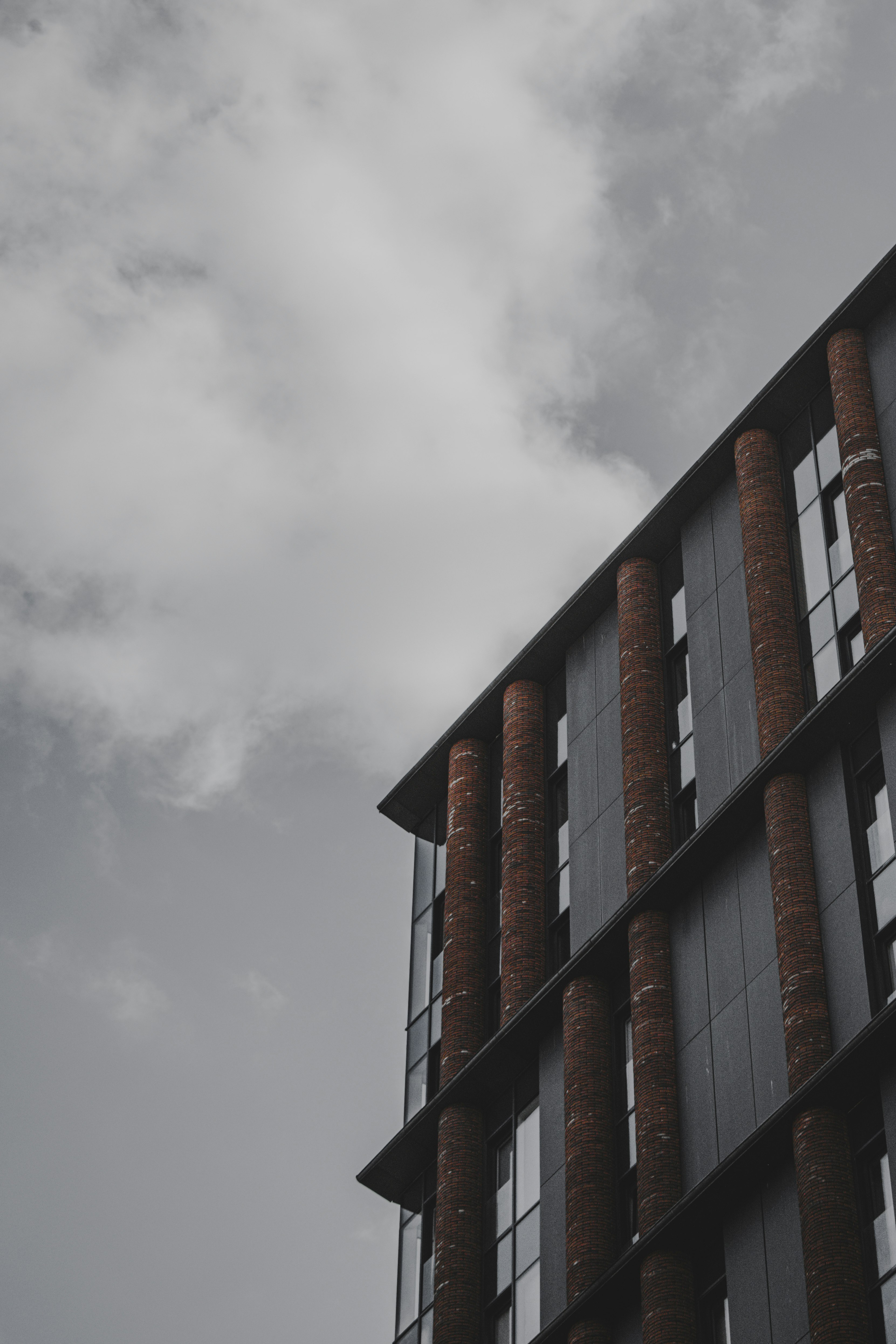 black and brown concrete building under white clouds